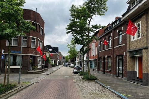 In de Hoensbroekse Hoofdstraat kon letterlijk en figuurlijk de vlag uit vanwege het besluit van de gemeente Heerlen. — © De Limburger